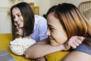 Glückliche junge Frauen sehen sich zu Hause einen Film an - XLGF01780