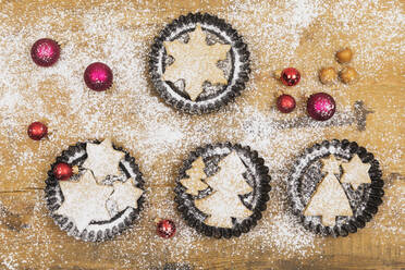 Weihnachtsschmuck und frische, selbstgebackene Kekse auf einer Holzunterlage - GWF06996