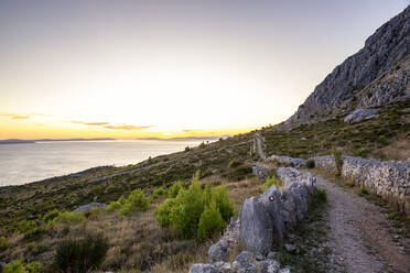 Leerer Wanderweg auf einem Hügel in der Nähe des Adriatischen Meeres in Omis, Dalmatien, Kroatien - MAMF01769