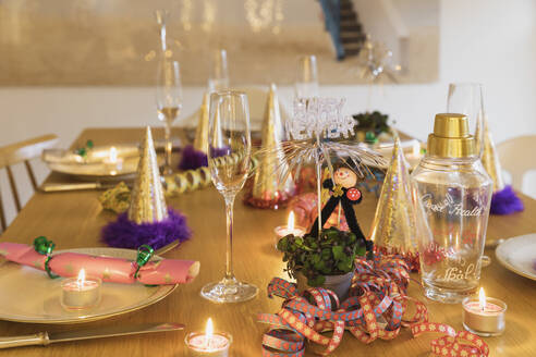 Festlich gedeckter Silvestertisch mit Tellern, Kerzen, Partyhüten, Sektflöten und Schornsteinfegerfiguren - GWF07002