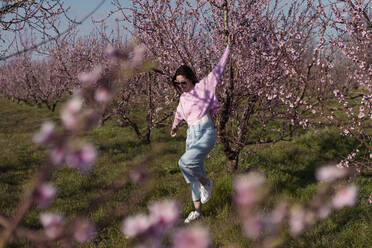 Mid erwachsene Frau tanzen in Pfirsich Feld während sonnigen Tag - MAUF03728