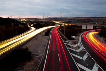 Autoampel auf der Autobahn bei Sonnenuntergang, Langzeitbelichtung, gelbe, rote und orange Lichter. - CAVF94044