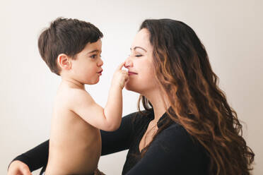 Ein Kleinkind berührt die Nase seiner Mutter. - CAVF94056