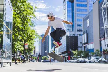 Junger Skateboarder macht einen Flip-Trick auf dem Boden - CAVF94071