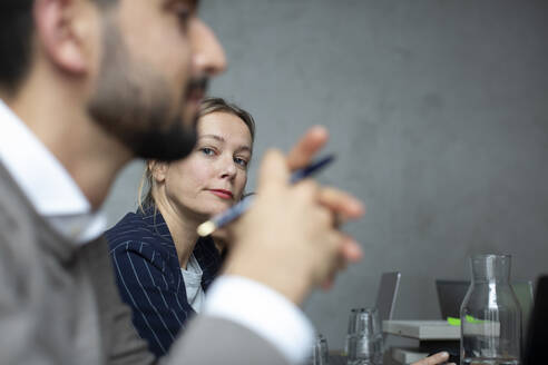 Geschäftsfrau mit männlichem Kollegen im Gespräch während eines Treffens im Kreativbüro - MASF23086