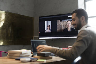 Männlicher Unternehmer in Videokonferenz mit Kunden im Büro - MASF23127