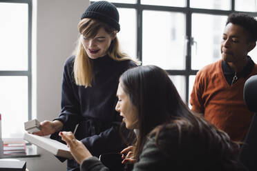 Weibliche und männliche Mitarbeiter diskutieren über ein Produkt im Büro - MASF23178