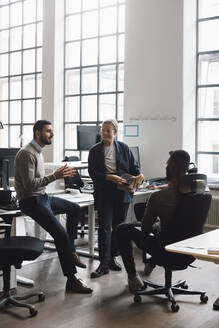 Male and female coworkers planning during meeting in creative office - MASF23186