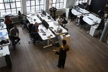 Businesswoman giving presentation to colleagues during meeting at creative office - MASF23197