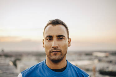 Porträt eines selbstbewussten männlichen Athleten gegen den Himmel bei Sonnenuntergang - MASF23370