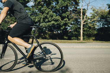 Niedriger Ausschnitt eines Sportlers beim Radfahren auf der Straße an einem sonnigen Tag - MASF23459