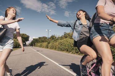 Fröhliche Freundinnen, die sich beim Radfahren auf der Straße vergnügen - MASF23517