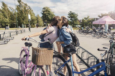 Female friends greeting at park on sunny day - MASF23526