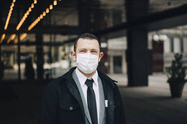 Portrait of businessman with protective face mask - MASF23576