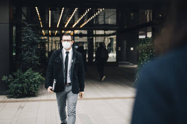 Male entrepreneur walking on footpath during pandemic - MASF23577