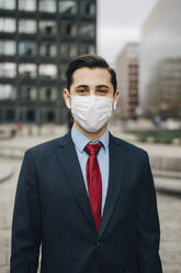 Portrait of businessman in office park during pandemic - MASF23583