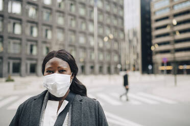 Porträt einer Geschäftsfrau auf der Straße in einer Stadt während der Pandemie - MASF23589