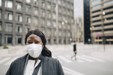 Portrait of businesswoman on street in city during pandemic - MASF23589