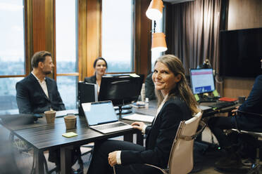 Porträt einer Anwältin mit Kollegen während einer Besprechung im Büro - MASF23634
