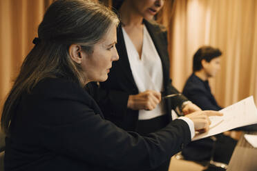 Geschäftsfrau, die mit einer Anwältin im Büro über ein Rechtsdokument diskutiert - MASF23635