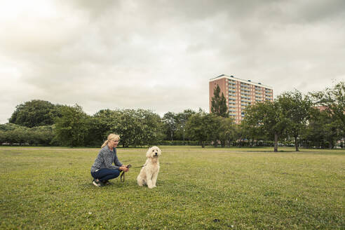 Reife Frau verbringt ihre Freizeit mit Hund im Park - MASF23774