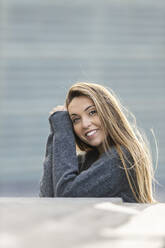 Smiling beautiful woman leaning on retaining wall - MTBF00982