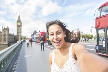 Fröhliche Frau macht ein Selfie auf einem Fußweg in London, England, UK - WPEF04445