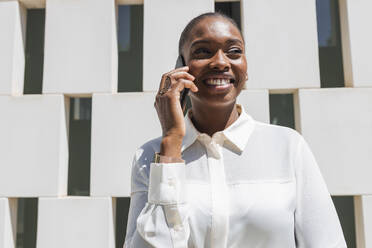 Female business person smiling while talking on mobile phone - JRVF00582