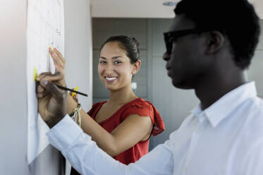 Smiling businesswoman working with colleague in office - BMOF00590