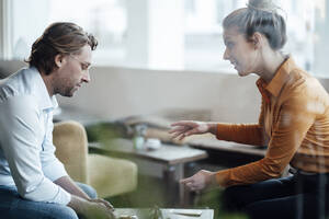 Female entrepreneur discussing with colleague at coffee shop - JOSEF04367