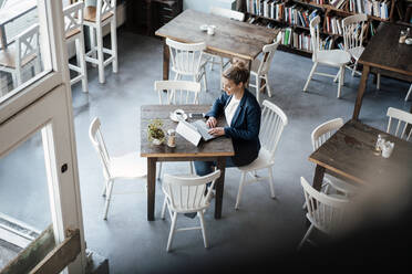 Unternehmerin arbeitet an einem Laptop in einem Café - JOSEF04379
