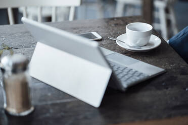 Digitales Tablet mit Kaffeetasse auf Holztisch im Café - JOSEF04380
