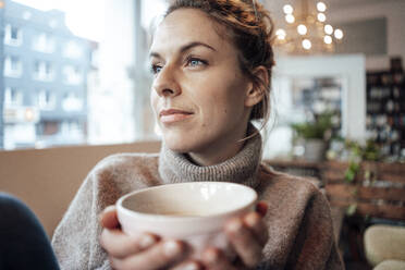 Mittlere erwachsene Frau mit Kaffee nachdenklich, während sie im Café wegschaut - JOSEF04419