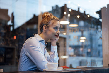 Female entrepreneur with hand on chin at cafe - JOSEF04421