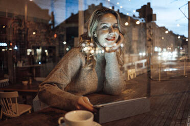 Lächelnde Frau mit Hand am Kinn im Café - JOSEF04433