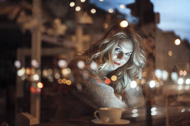 Blond female customer sitting at cafe - JOSEF04441