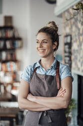 Confident mid adult owner standing with arms crossed at cafe - JOSEF04461