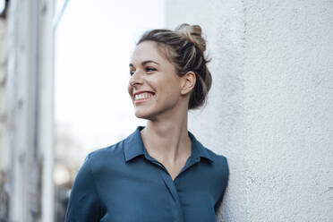 Mid adult businesswoman looking away while leaning on wall - JOSEF04476