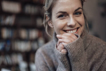 Schöne Frau im Pullover lächelnd im Café - JOSEF04487