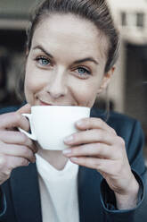 Mid adult businesswoman drinking coffee at cafe - JOSEF04503