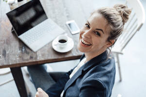 Mittlere erwachsene Geschäftsfrau mit digitalem Tablet auf dem Tisch eines Cafés - JOSEF04512