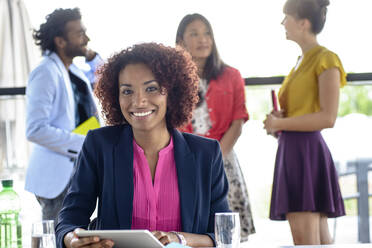 Smiling female entrepreneur with digital tablet in office - BMOF00621