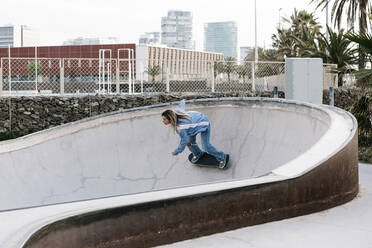 Mittlere erwachsene Frau beim Skateboarden im Park - XLGF01782