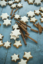 Christmas cinnamon star shaped cookies and cinnamon on blue rustic wooden background - ASF06753