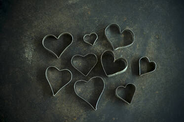 Heart shape cookie cutters on rustic baking sheet - ASF06759