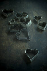 Heart shape cookie cutters on rustic baking sheet - ASF06760