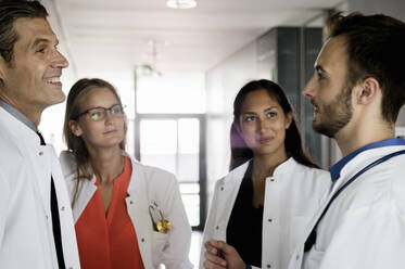 Smiling female and male doctors discussing in hospital - BMOF00631