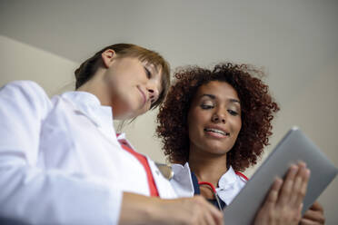 Ein Team von weiblichen Fachkräften diskutiert über ein digitales Tablet im Krankenhaus - BMOF00647