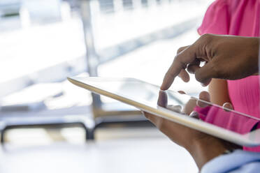 Male entrepreneur using digital tablet by female colleague at office - BMOF00671