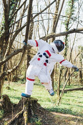 Astronautin hängt an einem Ast im Wald - MEUF02807